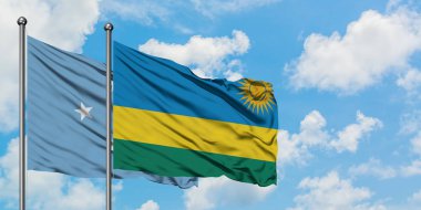 Mikronezya ve Ruanda bayrağı birlikte beyaz bulutlu mavi gökyüzüne karşı rüzgarda sallayarak. Diplomasi kavramı, uluslararası ilişkiler.