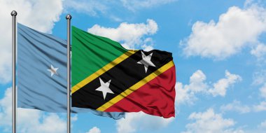 Mikronezya ve Saint Kitts ve Nevis bayrağı birlikte beyaz bulutlu mavi gökyüzüne karşı rüzgarda sallayarak. Diplomasi kavramı, uluslararası ilişkiler.