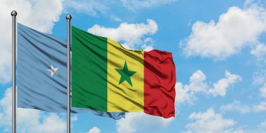 Mikronezya ve Senegal bayrağı birlikte beyaz bulutlu mavi gökyüzüne karşı rüzgarda sallayarak. Diplomasi kavramı, uluslararası ilişkiler.