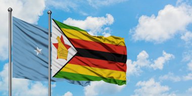 Mikronezya ve Zimbabve bayrağı birlikte beyaz bulutlu mavi gökyüzüne karşı rüzgarsal sallayarak. Diplomasi kavramı, uluslararası ilişkiler.