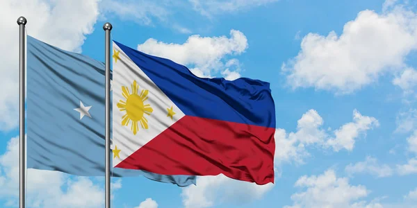 Bandera de Micronesia y Filipinas ondeando en el viento contra el cielo azul nublado blanco juntos. Concepto diplomático, relaciones internacionales . — Foto de Stock