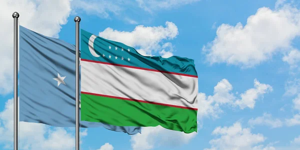 Bandera de Micronesia y Uzbekistán ondeando en el viento contra el cielo azul nublado blanco juntos. Concepto diplomático, relaciones internacionales . — Foto de Stock