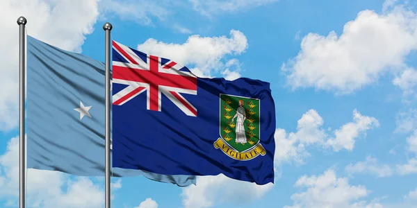 Mikronezya ve İngiliz Virgin Adaları bayrağı birlikte beyaz bulutlu mavi gökyüzüne karşı rüzgarda sallayarak. Diplomasi kavramı, uluslararası ilişkiler. — Stok fotoğraf