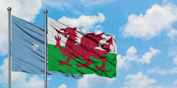Micronésia e bandeira do País de Gales agitando no vento contra o céu azul nublado branco juntos. Conceito de diplomacia, relações internacionais . — Fotografia de Stock