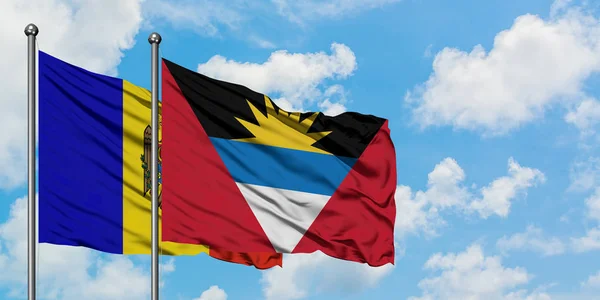 Moldavia y Antigua y Barbuda ondean en el viento contra el cielo azul nublado blanco juntos. Concepto diplomático, relaciones internacionales . — Foto de Stock