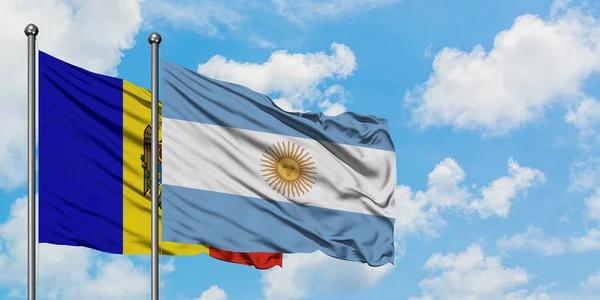 Moldávia e Argentina bandeira acenando no vento contra o céu azul nublado branco juntos. Conceito de diplomacia, relações internacionais . — Fotografia de Stock