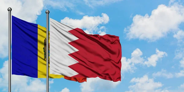 Bandera de Moldavia y Bahréin ondeando en el viento contra el cielo azul nublado blanco juntos. Concepto diplomático, relaciones internacionales . —  Fotos de Stock