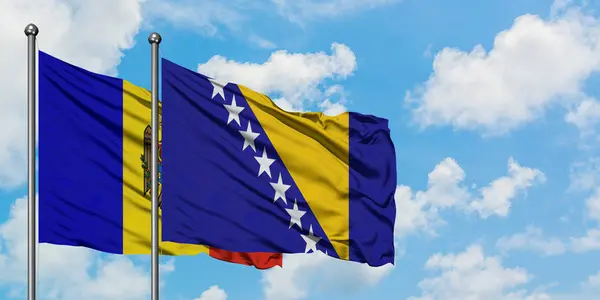 Η Μολδαβία και η Βοσνία Ερζεγοβίνη φέρουν σημαία που κουνώντας τον άνεμο κατά του λευκού νεφελώδη μπλε ουρανού μαζί. Φιλοσοφία της διπλωματίας, διεθνείς σχέσεις. — Φωτογραφία Αρχείου