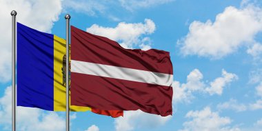 Moldova ve Letonya bayrağı birlikte beyaz bulutlu mavi gökyüzüne karşı rüzgarda sallayarak. Diplomasi kavramı, uluslararası ilişkiler.