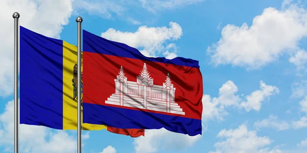 Moldavsko a Kambodžská vlajka mávali ve větru proti bíle zatažené modré obloze. Diplomacie, mezinárodní vztahy. — Stock fotografie
