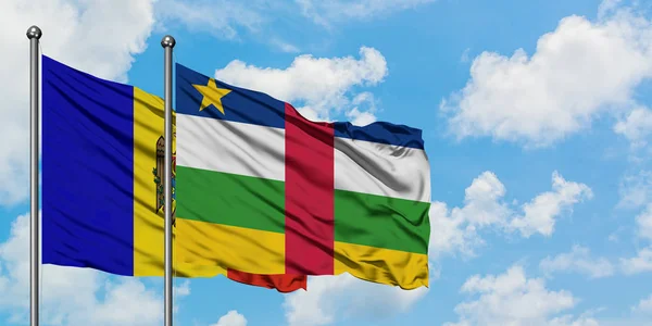 Moldavia y la República Centroafricana ondean en el viento contra el cielo azul nublado blanco juntos. Concepto diplomático, relaciones internacionales . — Foto de Stock