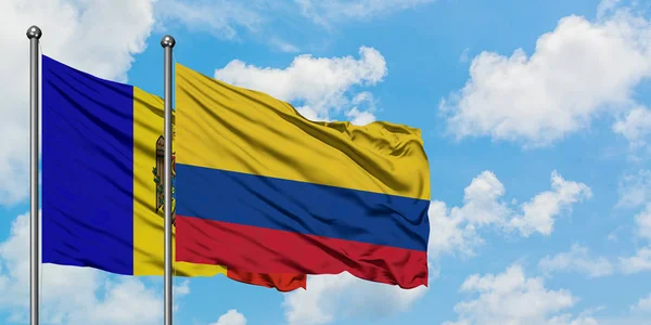 Bandera de Moldavia y Colombia ondeando en el viento contra el cielo azul nublado blanco juntos. Concepto diplomático, relaciones internacionales . — Foto de Stock
