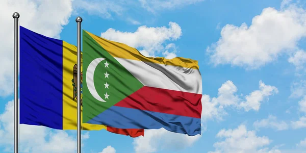 Bandera de Moldavia y Comoras ondeando en el viento contra el cielo azul nublado blanco juntos. Concepto diplomático, relaciones internacionales . — Foto de Stock