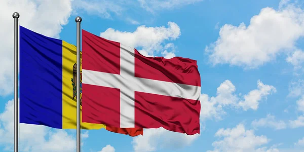 Moldavien och Danmark flagga vifta i vinden mot vit grumlig blå himmel tillsammans. Diplomatisk koncept, internationella relationer. — Stockfoto