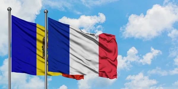 Bandera de Moldavia y Francia ondeando en el viento contra el cielo azul nublado blanco juntos. Concepto diplomático, relaciones internacionales . —  Fotos de Stock