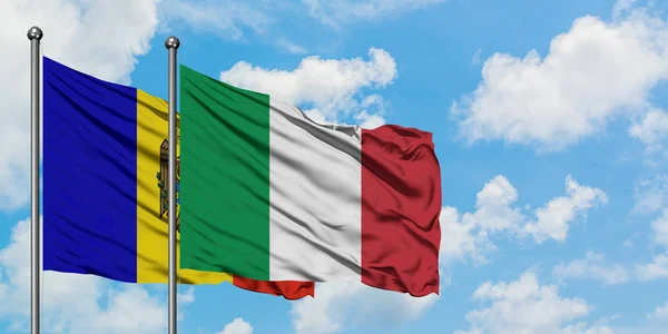 Bandera de Moldavia e Italia ondeando en el viento contra el cielo azul nublado blanco juntos. Concepto diplomático, relaciones internacionales . — Foto de Stock