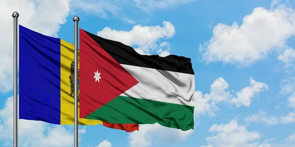 Bandera de Moldavia y Jordania ondeando en el viento contra el cielo azul nublado blanco juntos. Concepto diplomático, relaciones internacionales . — Foto de Stock