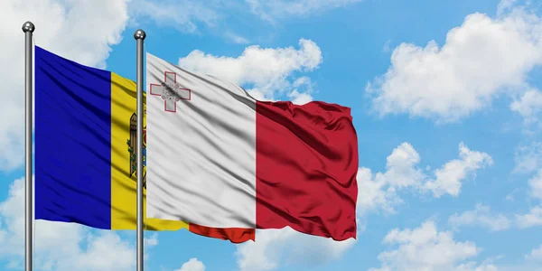 Μολδαβία και Μάλτα σημαία κουνώντας τον άνεμο κατά λευκό συννεφιασμένο γαλάζιο του ουρανού μαζί. Φιλοσοφία της διπλωματίας, διεθνείς σχέσεις. — Φωτογραφία Αρχείου