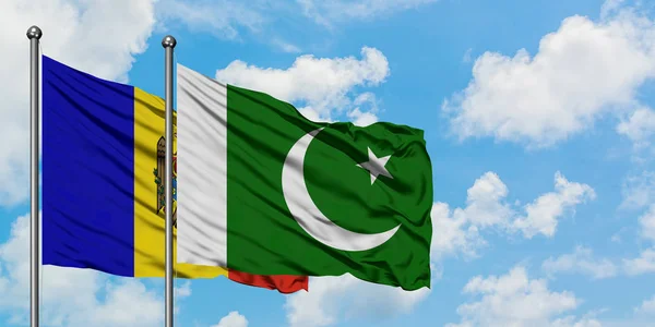 Bandera de Moldavia y Pakistán ondeando en el viento contra el cielo azul nublado blanco juntos. Concepto diplomático, relaciones internacionales . — Foto de Stock