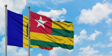 Moldova ve Togo bayrağı birlikte beyaz bulutlu mavi gökyüzüne karşı rüzgarda sallayarak. Diplomasi kavramı, uluslararası ilişkiler.