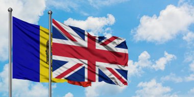 Moldova ve Birleşik Krallık bayrağı birlikte beyaz bulutlu mavi gökyüzüne karşı rüzgarsal sallayarak. Diplomasi kavramı, uluslararası ilişkiler.