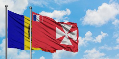 Moldova ve Wallis ve Futuna bayrağı birlikte beyaz bulutlu mavi gökyüzüne karşı rüzgarda sallayarak. Diplomasi kavramı, uluslararası ilişkiler.