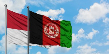 Monako ve Afganistan bayrağı birlikte beyaz bulutlu mavi gökyüzüne karşı rüzgarda sallayarak. Diplomasi kavramı, uluslararası ilişkiler.