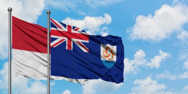 Monako ve Anguilla bayrağı birlikte beyaz bulutlu mavi gökyüzüne karşı rüzgarda sallayarak. Diplomasi kavramı, uluslararası ilişkiler.