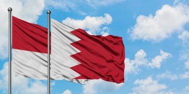 Monako ve Bahreyn bayrağı birlikte beyaz bulutlu mavi gökyüzüne karşı rüzgarda sallayarak. Diplomasi kavramı, uluslararası ilişkiler.