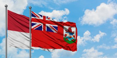 Monako ve Bermuda bayrağı birlikte beyaz bulutlu mavi gökyüzüne karşı rüzgarda sallayarak. Diplomasi kavramı, uluslararası ilişkiler.