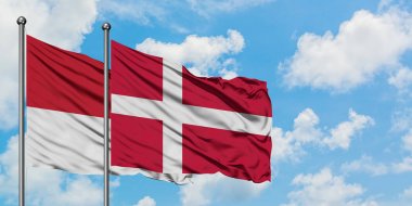 Monako ve Danimarka bayrağı birlikte beyaz bulutlu mavi gökyüzüne karşı rüzgarda sallayarak. Diplomasi kavramı, uluslararası ilişkiler.