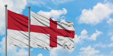 Monako ve İngiltere bayrağı birlikte beyaz bulutlu mavi gökyüzüne karşı rüzgarda sallayarak. Diplomasi kavramı, uluslararası ilişkiler.