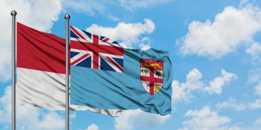 Monako ve Fiji bayrağı birlikte beyaz bulutlu mavi gökyüzüne karşı rüzgarda sallayarak. Diplomasi kavramı, uluslararası ilişkiler.