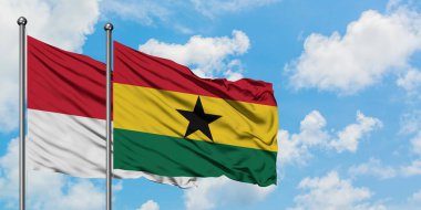 Monako ve Gana bayrağı birlikte beyaz bulutlu mavi gökyüzüne karşı rüzgarda sallayarak. Diplomasi kavramı, uluslararası ilişkiler.