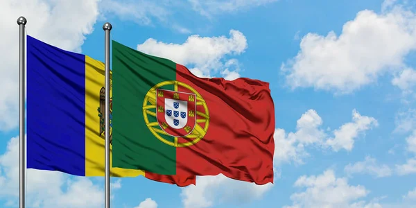 Bandera de Moldavia y Portugal ondeando en el viento contra el cielo azul nublado blanco juntos. Concepto diplomático, relaciones internacionales . — Foto de Stock