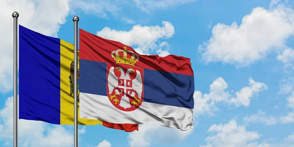 Bandera de Moldavia y Serbia ondeando en el viento contra el cielo azul nublado blanco juntos. Concepto diplomático, relaciones internacionales . — Foto de Stock