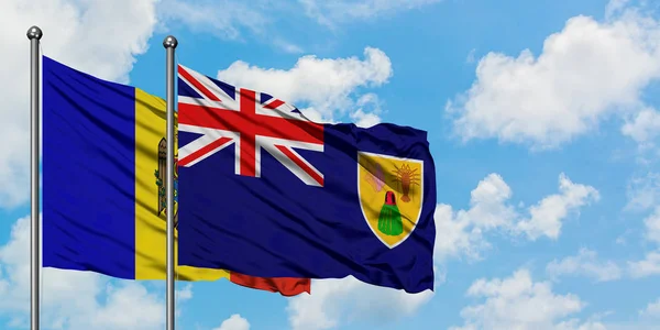 Moldavië en Turks-en Caicoseilanden vlag zwaaien in de wind tegen witte bewolkte blauwe hemel samen. Diplomatie concept, internationale betrekkingen. — Stockfoto
