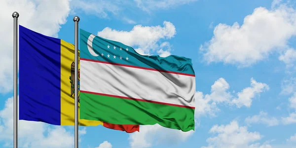 Bandera de Moldavia y Uzbekistán ondeando en el viento contra el cielo azul nublado blanco juntos. Concepto diplomático, relaciones internacionales . — Foto de Stock