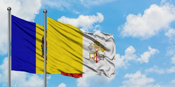 摩尔多瓦和梵蒂冈城旗在风中飘扬，白云蓝天相聚。外交概念、国际关系. — 图库照片