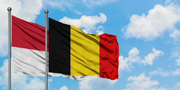 Monaco en België vlag zwaaien in de wind tegen witte bewolkte blauwe hemel samen. Diplomatie concept, internationale betrekkingen. — Stockfoto