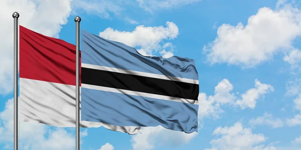 摩纳哥和博茨瓦纳国旗在风中飘扬，与白云蓝天相一起。外交概念、国际关系. — 图库照片