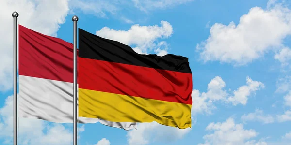 Monaco and Germany flag waving in the wind against white cloudy blue sky together. Diplomacy concept, international relations. — Stock Photo, Image