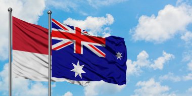 Monako ve Heard Adası ve Mcdonald Adaları bayrağı birlikte beyaz bulutlu mavi gökyüzüne karşı rüzgarda sallayarak. Diplomasi kavramı, uluslararası ilişkiler.