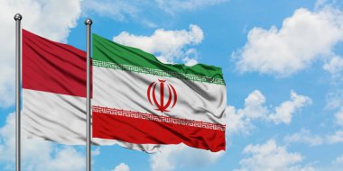 Monako ve İran bayrağı birlikte beyaz bulutlu mavi gökyüzüne karşı rüzgarsal sallayarak. Diplomasi kavramı, uluslararası ilişkiler.