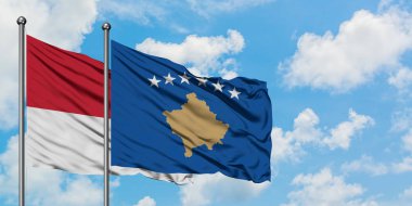 Monako ve Kosova bayrağı birlikte beyaz bulutlu mavi gökyüzüne karşı rüzgarda sallayarak. Diplomasi kavramı, uluslararası ilişkiler.