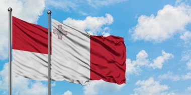 Monako ve Malta bayrağı birlikte beyaz bulutlu mavi gökyüzüne karşı rüzgarda sallayarak. Diplomasi kavramı, uluslararası ilişkiler.