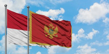 Monako ve Karadağ bayrağı birlikte beyaz bulutlu mavi gökyüzüne karşı rüzgarsal sallayarak. Diplomasi kavramı, uluslararası ilişkiler.