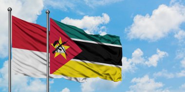 Monako ve Mozambik bayrağı birlikte beyaz bulutlu mavi gökyüzüne karşı rüzgarda sallayarak. Diplomasi kavramı, uluslararası ilişkiler.