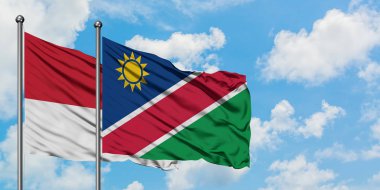 Monako ve Namibya bayrağı birlikte beyaz bulutlu mavi gökyüzüne karşı rüzgarda sallayarak. Diplomasi kavramı, uluslararası ilişkiler.