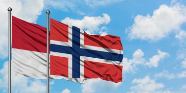 Monako ve Norveç bayrağı birlikte beyaz bulutlu mavi gökyüzüne karşı rüzgarsal sallayarak. Diplomasi kavramı, uluslararası ilişkiler.